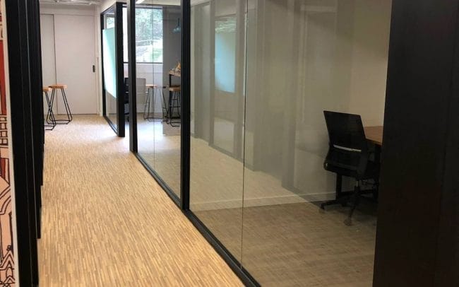 HK Works corridor between offices with lots of large glass walls